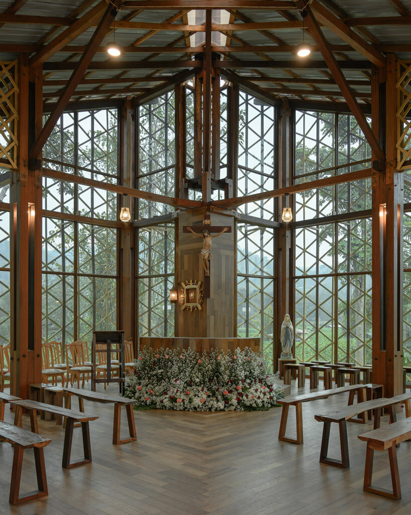 intricate timber latticework envelops st francis oratory amidst thailand's serene landscapes