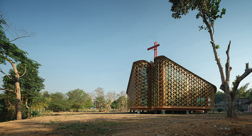 intricate timber latticework envelops st francis oratory amidst thailand's serene landscapes