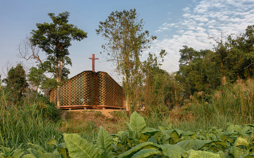 intricate timber latticework envelops st francis oratory amidst thailand's serene landscapes