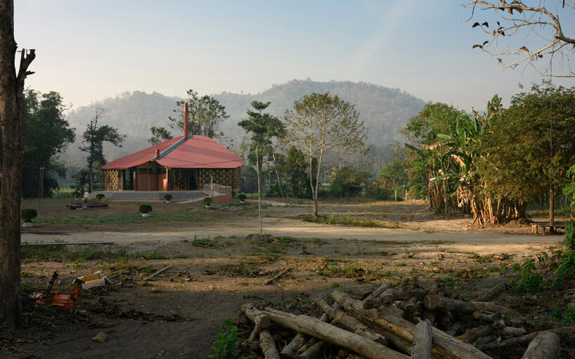 intricate timber latticework envelops st francis oratory amidst thailand's serene landscapes