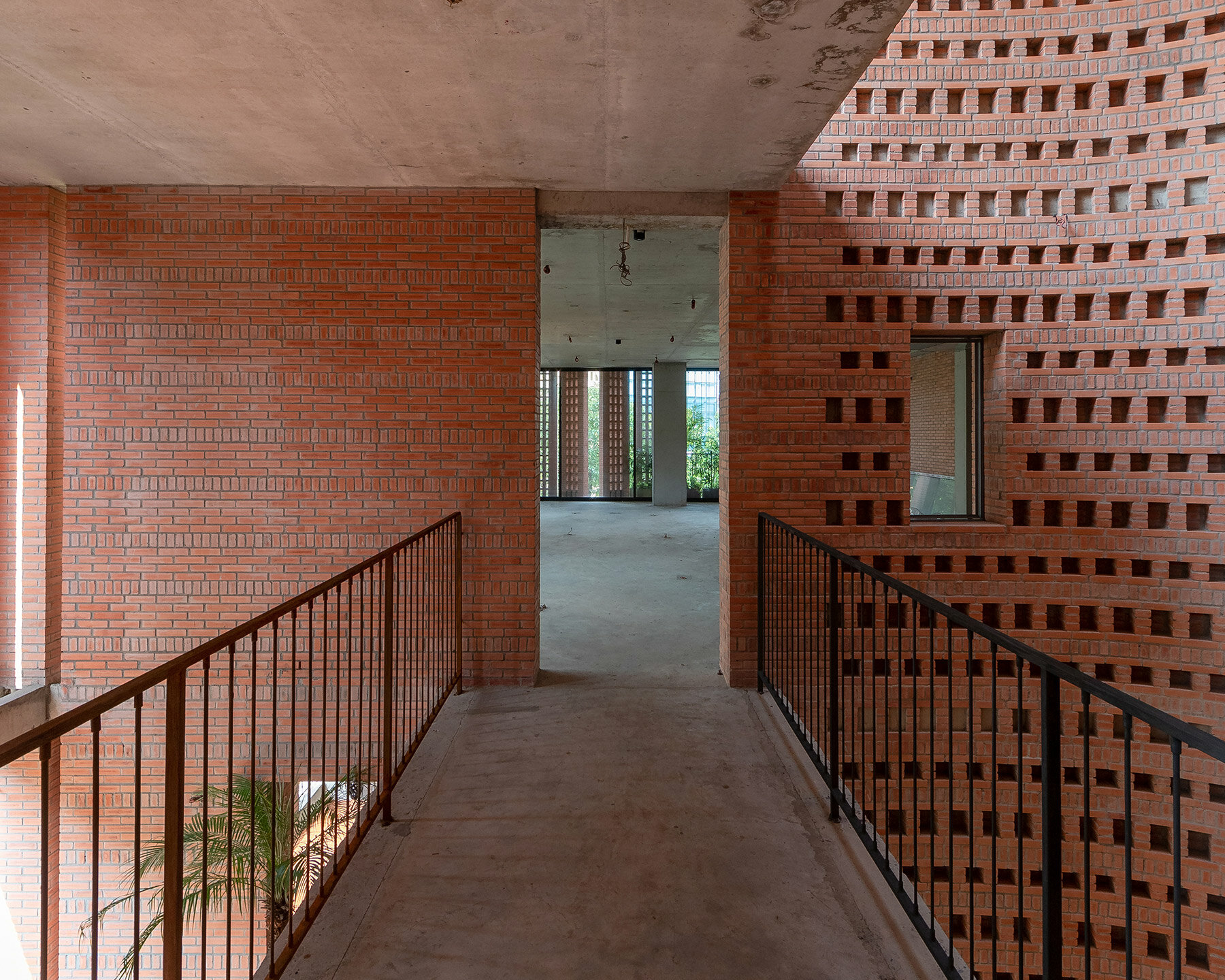 tropical space encloses 'premier office' with a porous brick facade