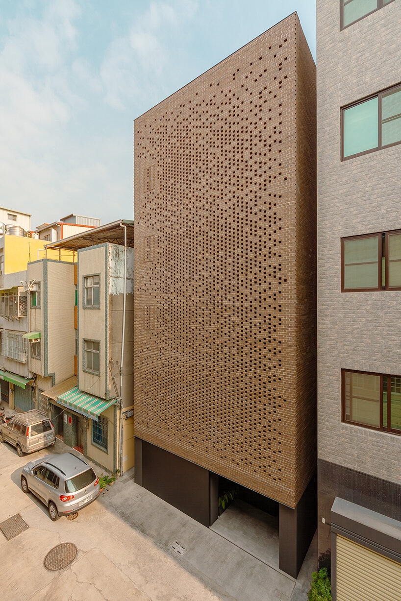 a tapestry-like facade made of clay bricks weaves across paperfarm's veil house in taiwan