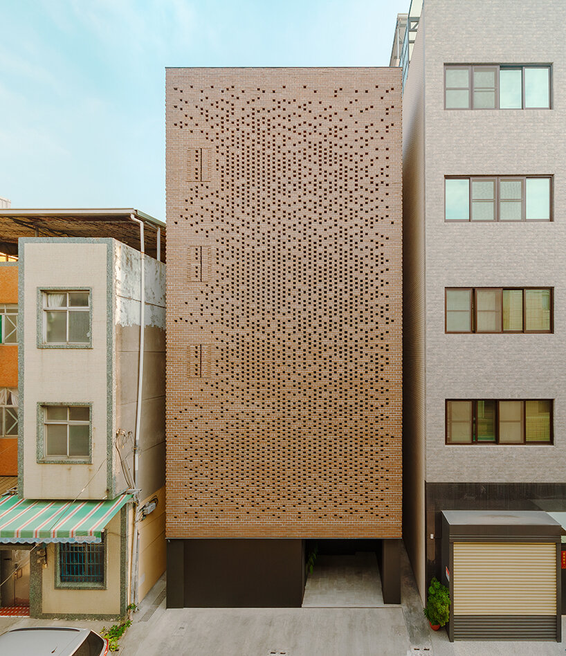 a tapestry-like facade made of clay bricks weaves across paperfarm's veil house in taiwan