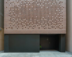 a tapestry-like facade made of clay bricks weaves across paperfarm's veil house in taiwan