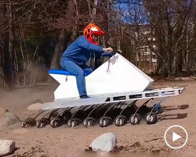 electric jet ski with 18 wheels surfs over water, land, & rocks as all-terrain centipede vehicle