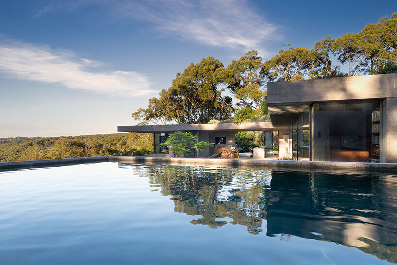 bunkeren house: half-buried volumes integrate with sloping rocky site in australian village