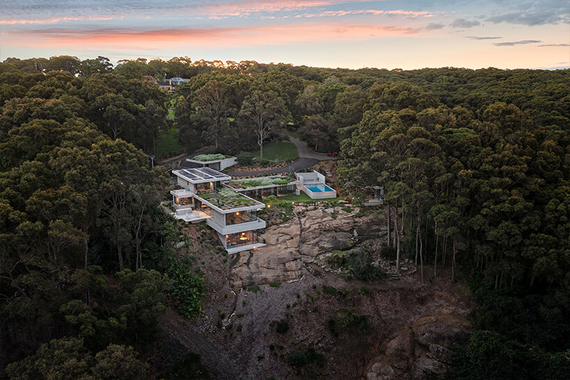 bunkeren house: half-buried volumes integrate with sloping rocky site in australian village