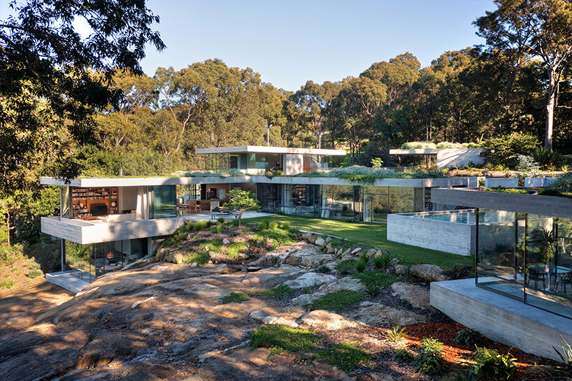 bunkeren house: half-buried volumes integrate with sloping rocky site in australian village