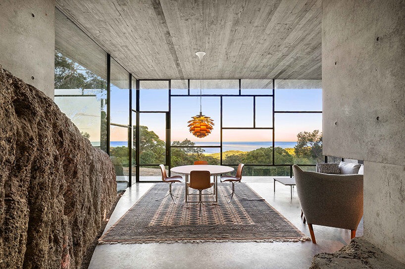 bunkeren house: half-buried volumes integrate with sloping rocky site in australian village