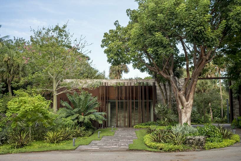 corten steel gatehouse overgrown by tropical nature in coconut grove, miami