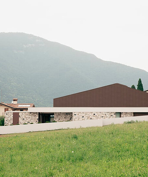 stone walls and warm wooden features adorn private residence in northern italy
