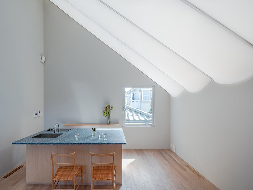 tubular membrane roof casts a soft glow over this two-story house in tokyo