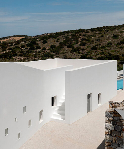 riza house's whitewashed walls emerge from arid greek landscape