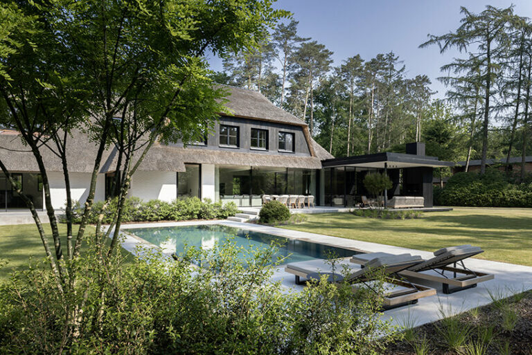 mieke van herck architects' sleek extension for thatched-roof house