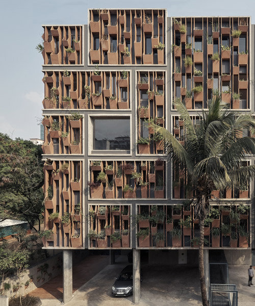 shared workspaces in india are wrapped in a living facade of stone planters