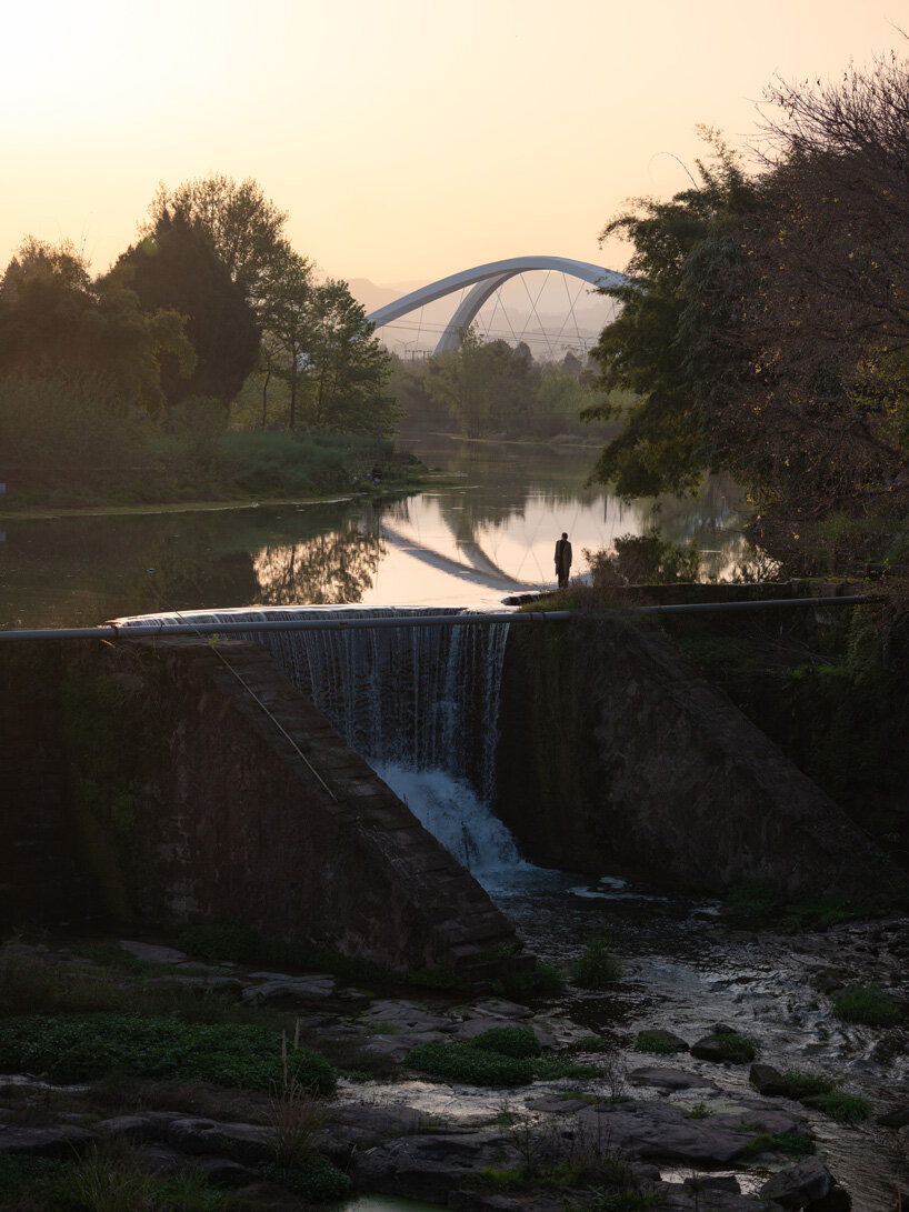 Οι αρχιτέκτονες της Ζάχα Χαντίντ σμιλεύουν διπλή τοξωτή συμμετρική γέφυρα στον ποταμό Jiangxi στην Κίνα