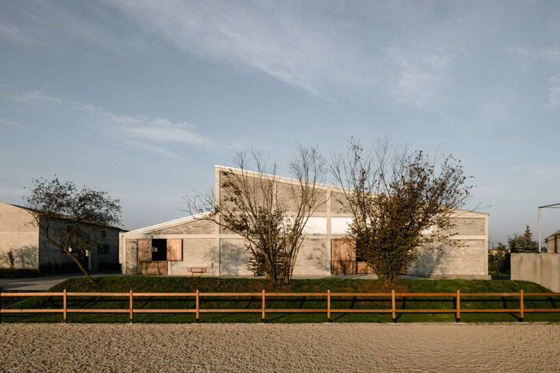 raw concrete, steel panels, and wood wrap wiercinski studio's equestrian center in poland