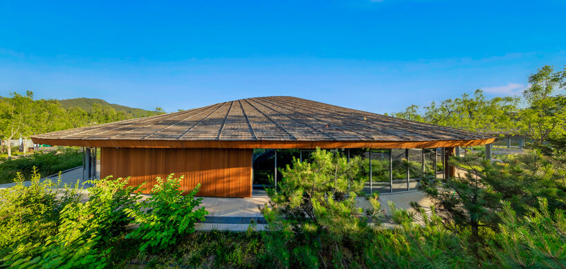sculptural roof informs the ring-shaped design of lake education center in china