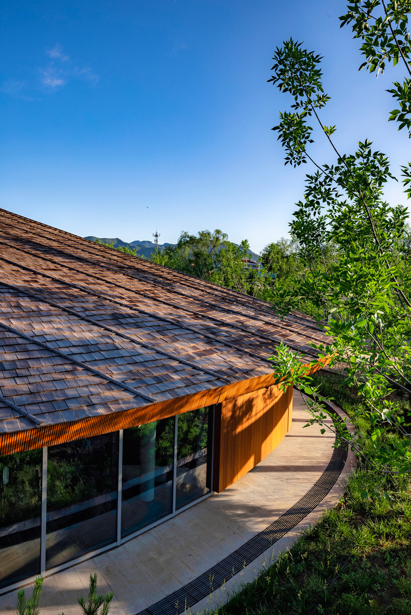 sculptural roof informs the ring-shaped design of lake education center in china