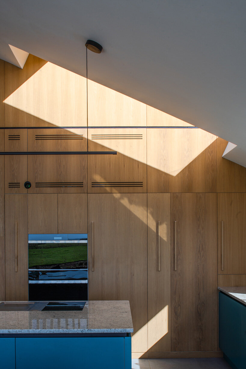 cluster of pitched timber volumes by coffey architects perch above dorset's sloping hillside