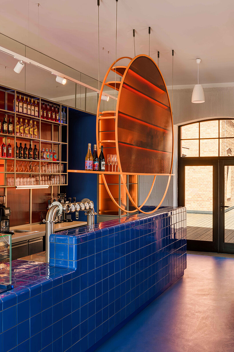 cobalt blue and warm orange tones pair up inside poland's pastry club woda