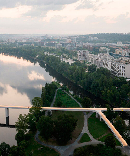 sleek concrete pedestrian bridge spans the vltava river in prague