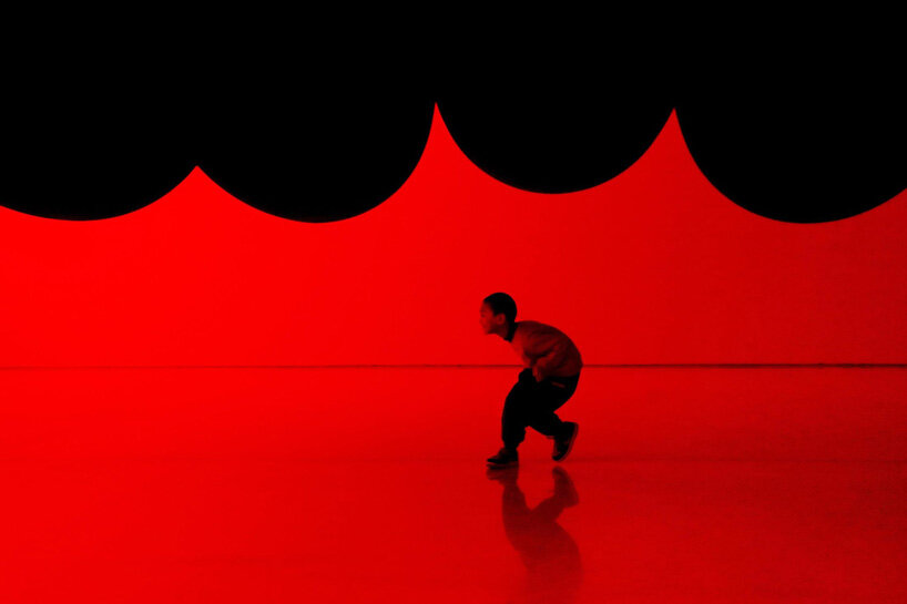 nine colossal tubes undulate and engulf visitors amid a red glow in SpY's beijing installation