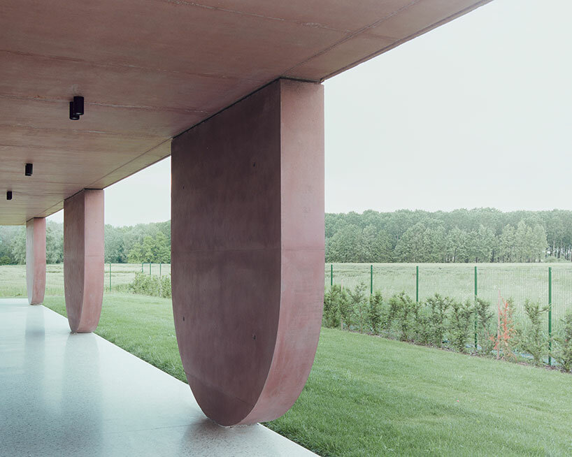 MIDE architetti's pink concrete residence curves around lush vegetation in italy