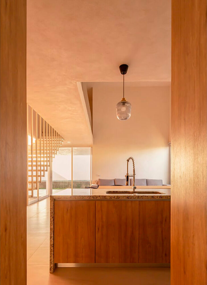 pink-hued sculptural wall emerges as casa banderas' west-facing facade in mexico