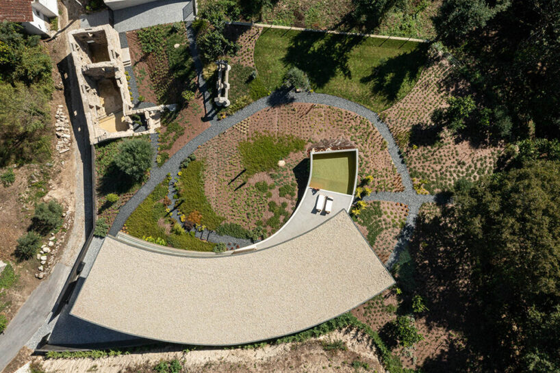 set like a bending body, mutant's casa de bouro seemingly hugs the portuguese landscape