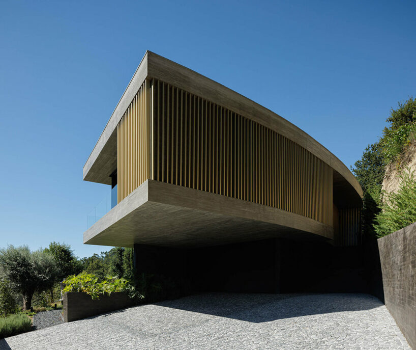 set like a bending body, mutant's casa de bouro seemingly hugs the portuguese landscape