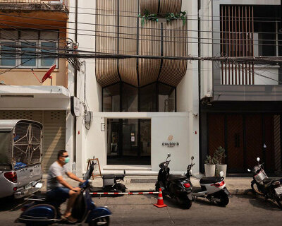 handcrafted wooden facade sweeps across VMA design studio’s hostel in bangkok