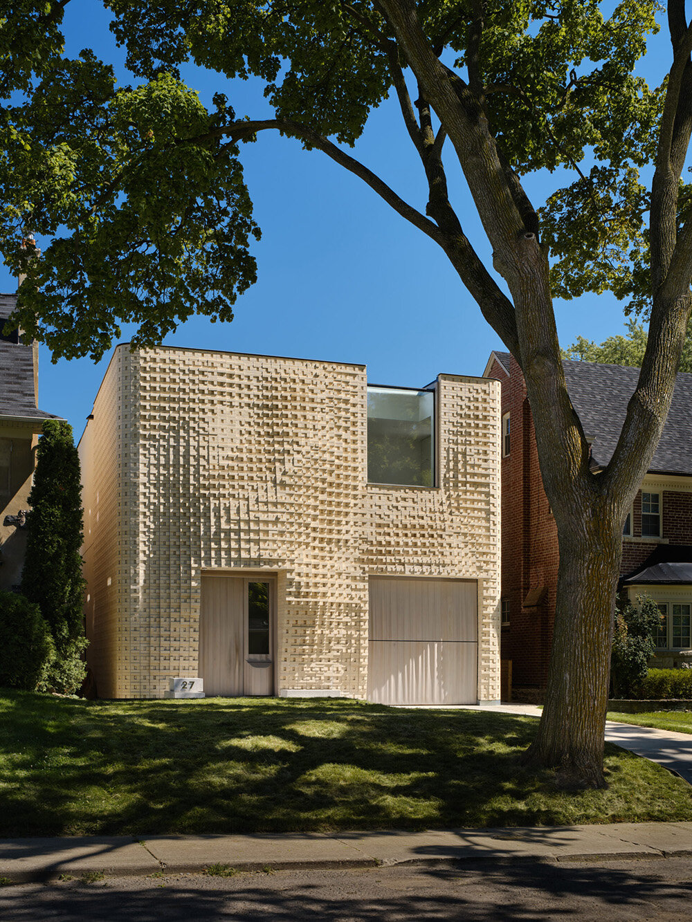 dramatic brick undulations flow across partisans' canvas house in toronto, canada