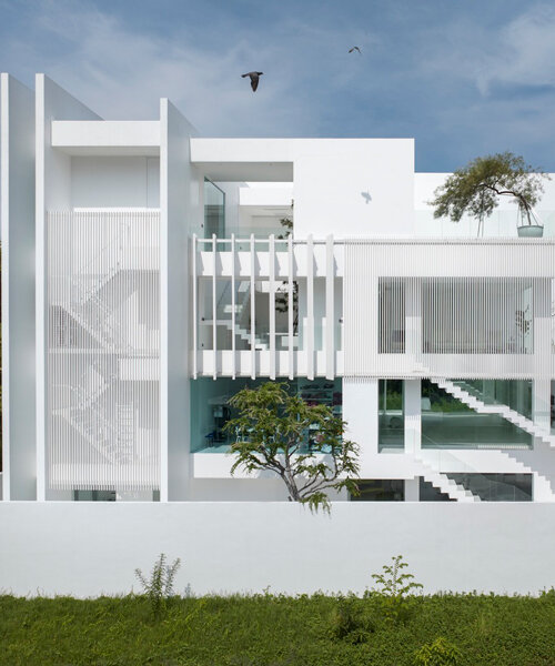 vertical white louvered surfaces enfold canvas house in bangkok