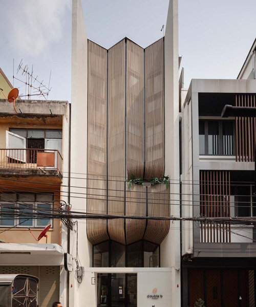 handcrafted wooden facade sweeps across VMA design studio’s hostel in bangkok