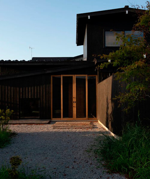 old japanese timber farmhouse transforms into modest hotel with U-shaped gardens