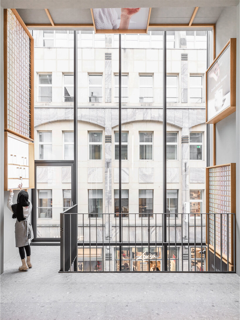 alleswirdgut installs wooden shelf system across shrine-inspired waterdrop store in cologne