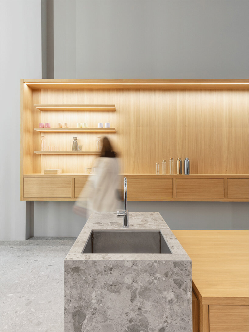 alleswirdgut installs wooden shelf system across shrine-inspired waterdrop store in cologne