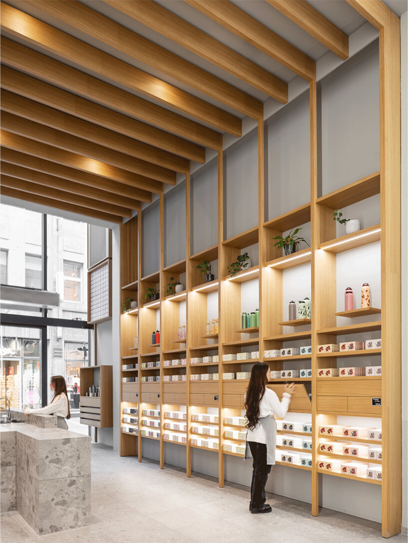 alleswirdgut installs wooden shelf system across shrine-inspired waterdrop store in cologne