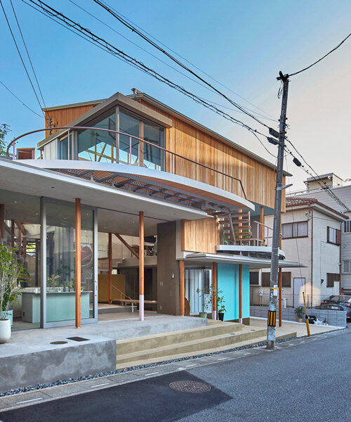 fragmented timber blue box office stands on sloping terrain in japan