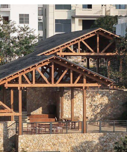 winding gabled roof tops galaxy arch's wood-framed community space in chinese village