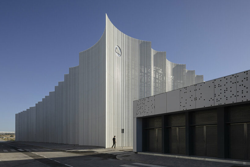 Arcos rítmicos y traslúcidos revisten el edificio del Centro Logístico Mayor en España