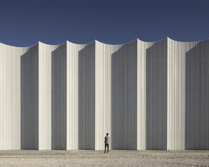 rhythmic and translucent arches envelop the mayoral logistics centre building in spain