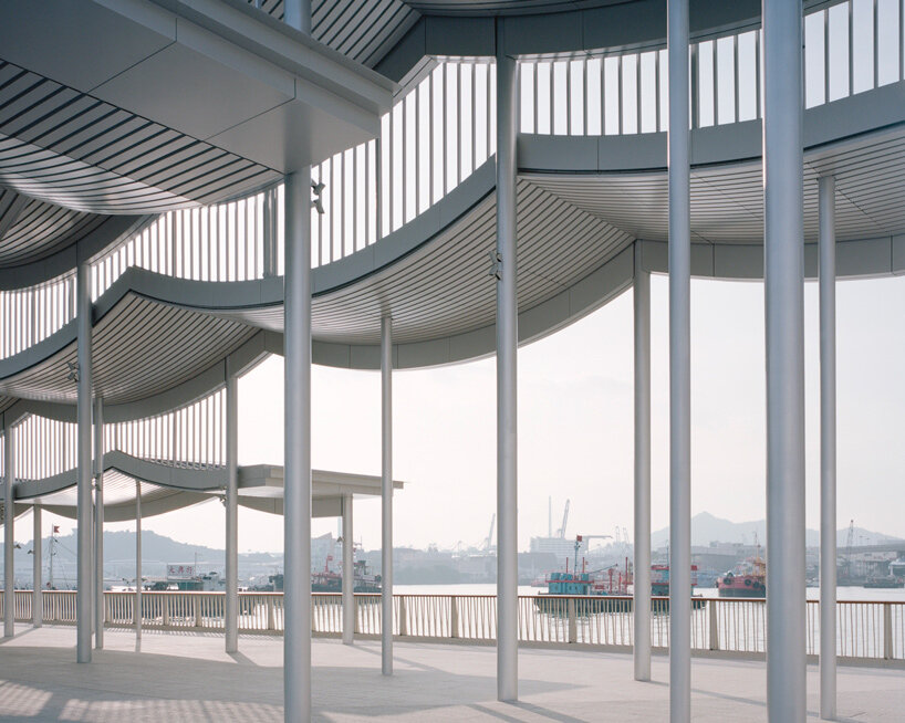 undulating canopy by new office works shelters waterfront promenade in hong kong