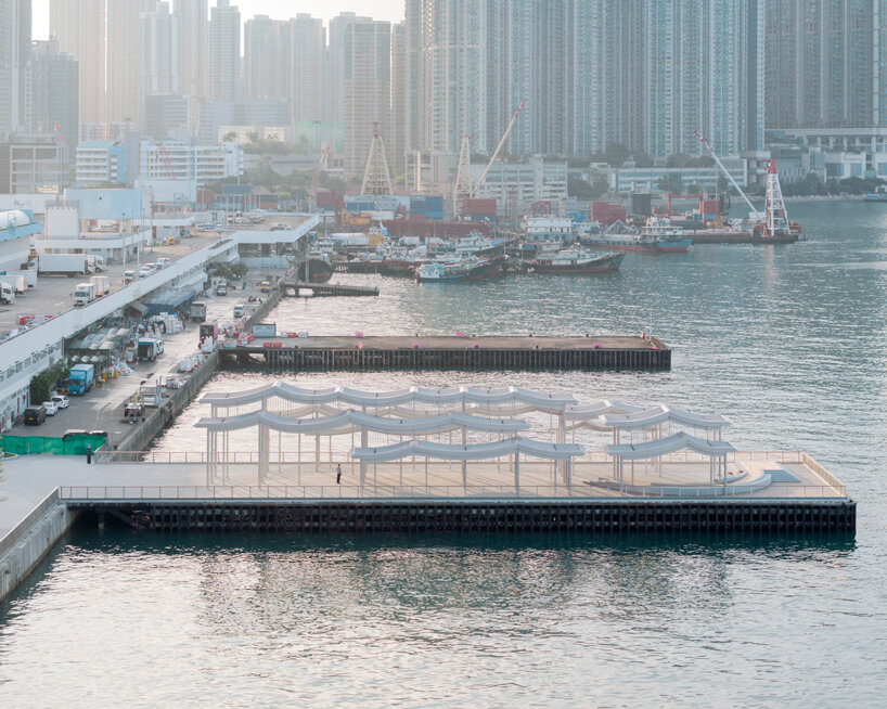 undulating canopy by new office works shelters waterfront promenade in hong kong