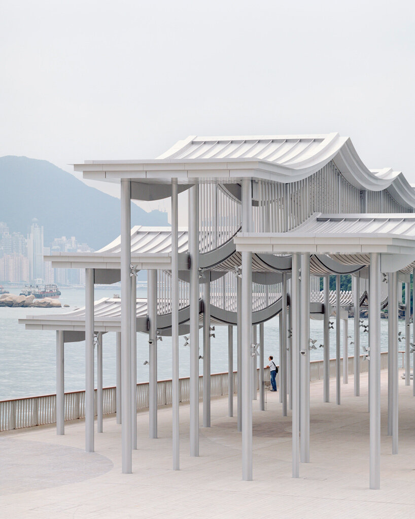 undulating canopy by new office works shelters waterfront promenade in hong kong