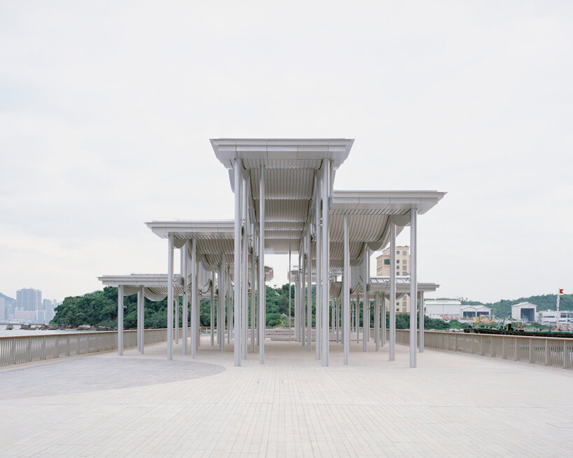 undulating canopy by new office works shelters waterfront promenade in hong kong