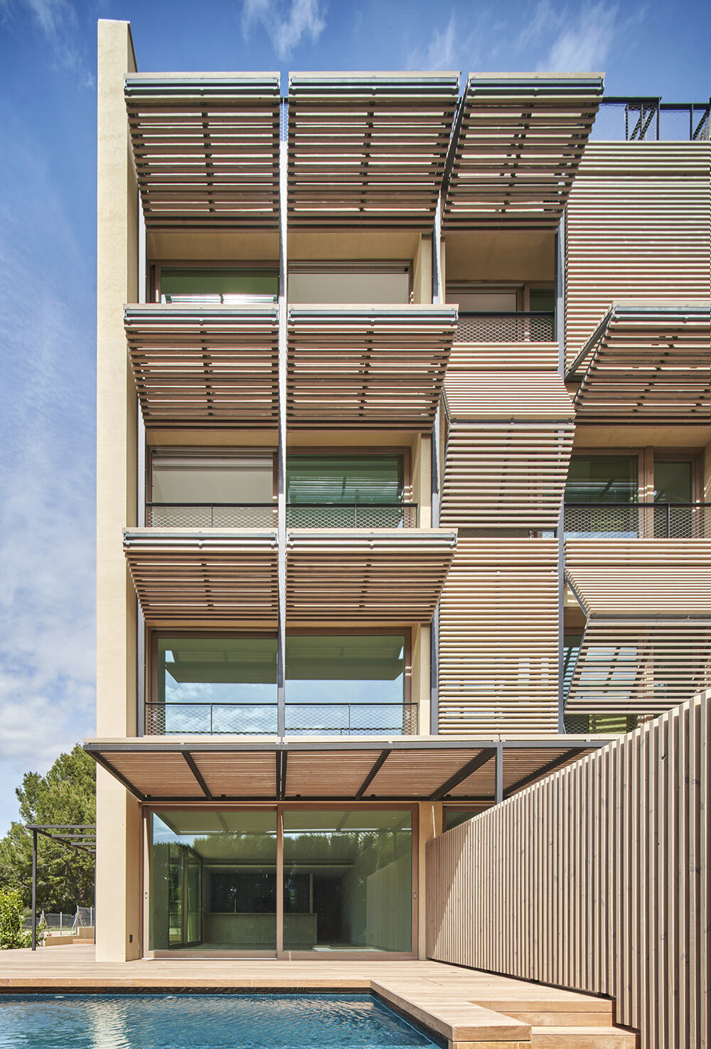 dynamic OHLAB facade switches from shutters to pergolas across paral·lel complex in spain