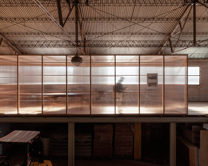 polycarbonate panels reflect light within minimalist atelier industrial in argentina