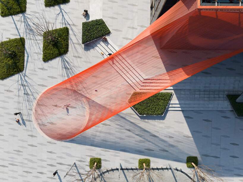 behin ha weaves temporary installation with orange fabric ribbons at hangzhou complex